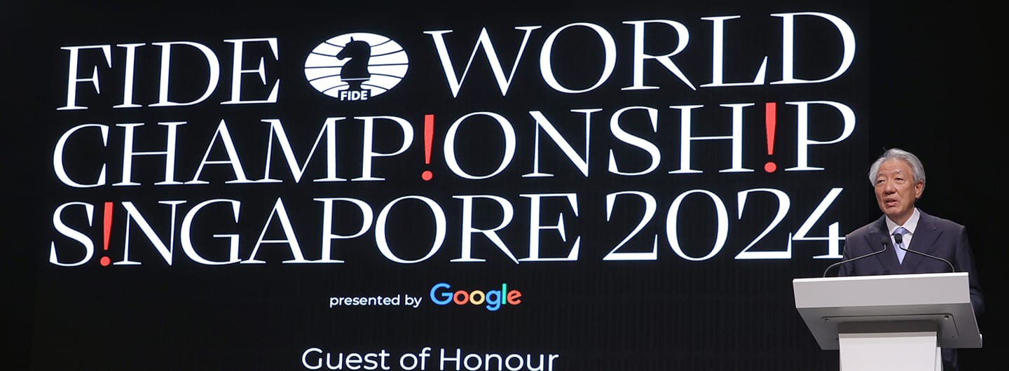 FIDE World Championship Singapore 2024 banner, Google presentation, man at podium.